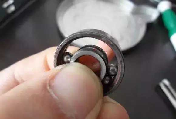 用手將軸承拿起，需要注意要向有滾珠的方向頂住